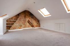 Loft conversion with exposed brick chimney breast